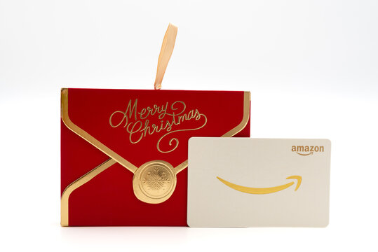Fuji, Shizuoka, Japan - November 14, 2024: An Amazon gift card placed next to a red decorative "Merry Christmas" envelope on a white background.