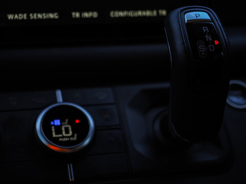 Gear shift and climate control console in off-road SUV at night