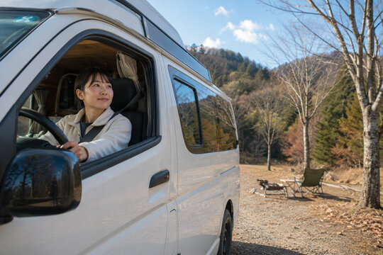 キャンピングカーを運転する笑顔の女性