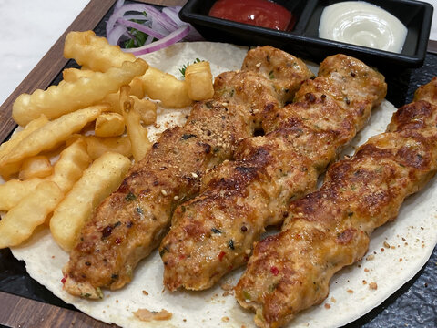 ラヴァッシュに乗ったチキンルラケバブ、ウェーブポテト付き中東料理プレート