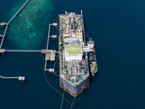 Aerial view of a Floating Storage and Offloading ship moored at an offshore terminal with a helipad and industrial infrastructure in Buleleng Regency, Bali, Indonesia.