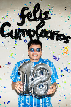 Young man celebrating 18th birthday and adulthood lying on floor