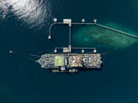 Aerial view of a Floating Storage and Offloading Ship moored at a jetty in the clear blue waters of the ocean in Buleleng Regency, Bali, Indonesia.