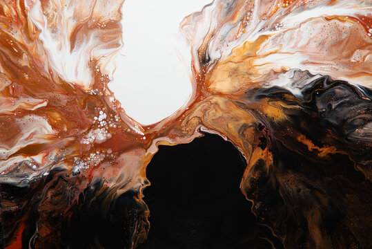 Acrylic pour abstract artwork on canvas, showing flowing paint in tones of gold, copper and and browns.