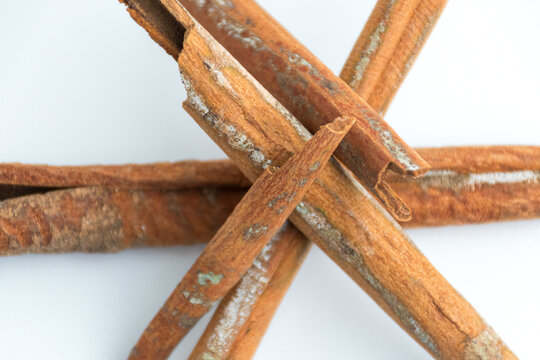 Cinnamon sticks arranged in crossed and star pattern isolated on white background