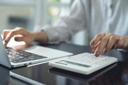 Business woman using calculator to calculate financial report, budget management. finance, accounting and budget planning, tax calculation