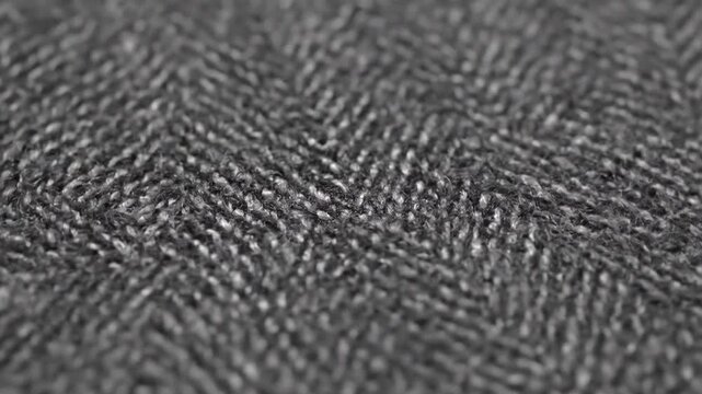 Close up texture of dark gray fabric material showcasing woven pattern detail, perfect for textile design or fashion backgrounds, soft subtle backdrop element