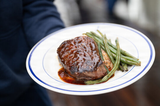 A plated meal of steak, risotto and green beans