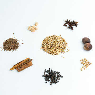 Assortment of dry cooking spices including cinnamon star anise coriander and nutmeg isolated on white