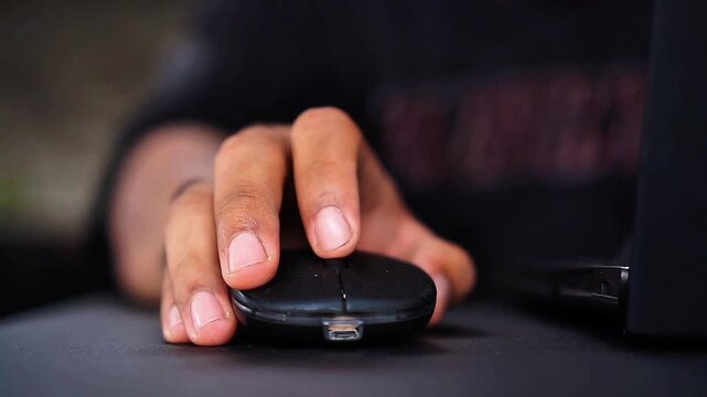 Professional user operating a black computer mouse during productive office work or creative digital tasks at home