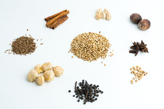 Assortment of dry cooking spices including cinnamon star anise coriander and nutmeg isolated on white
