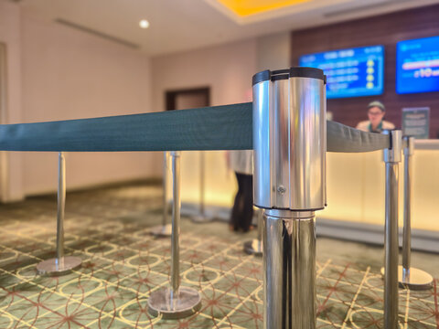 ​Queue barrier belt post in modern hotel lobby reception counter with blurred background for crowd control and queue management service line
