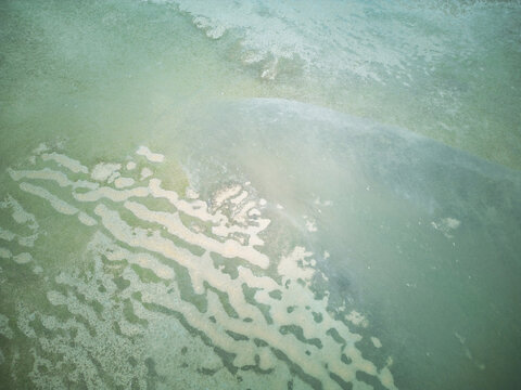Aerial view of abstract turquoise sea patterns and sandbar texture