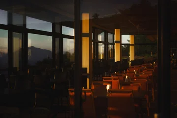 Fotobehang Horeca Cozy mountain lodge restaurant interior glowing with warm lantern lights at dusk  © 豊田　達矢
