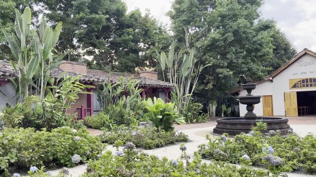 Tilt Up Shot of Colonial Courtyard with Fountain and Lush Garden at Sunset