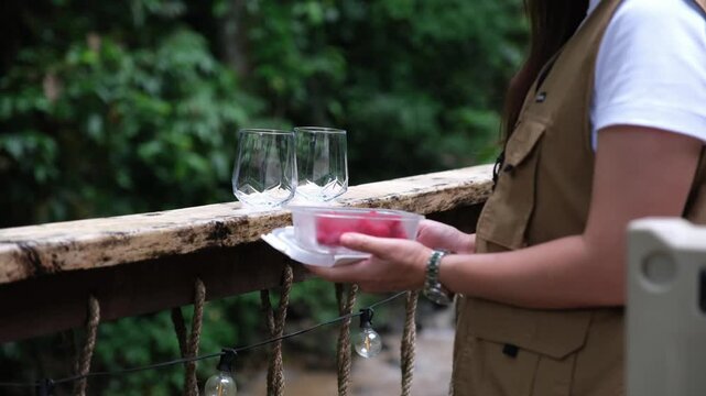 A woman putting raspberry in glasses to make a drinks