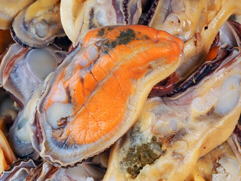 Close-up of raw orange mussel flesh without shell ready for culinary preparation.