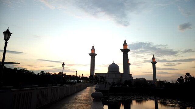 Sunset at Baiturrahman Grand Mosque in Banda Aceh, Indonesia &ndash; Silhouetted Minarets and Dome Reflecting on Water