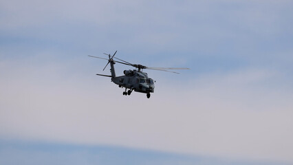 Fototapeta premium Military Sikorsky MH-60R Seahawk Helicopter Flying Against a Cloudy Sky