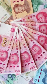 Chinese yuan (CNY) or renminbi (RMB) bills of diffrent value. Top view vertical footage with slow rotation. Saving money, financial income and growth, business concept