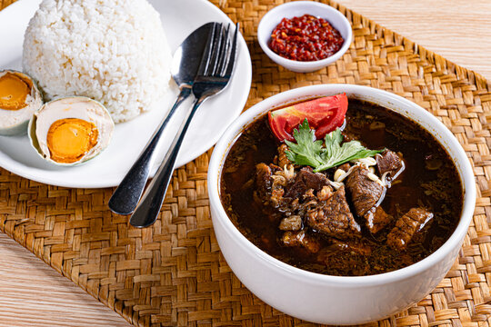 Complete east javanese rawon meal set with white rice and woven placemat
