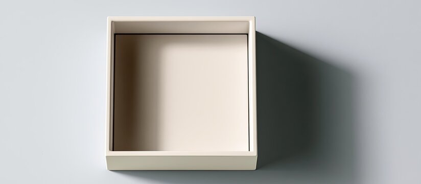 Empty beige open box casts a shadow on a light gray background