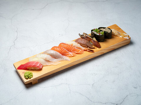 Various types of sushi served on a wooden cutting board