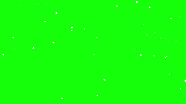 Floating white confetti particles falling against green screen background