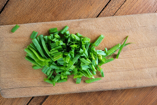 Fresh Chopped Green Spring Onions on Wooden Cutting Board