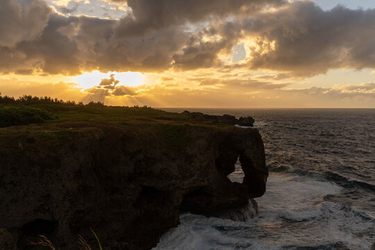 夕暮れ時の万座毛と断崖絶壁に差し込む夕日・沖縄県恩納村 the Manzamo cliff and ocean in Onna Village, Okinawa