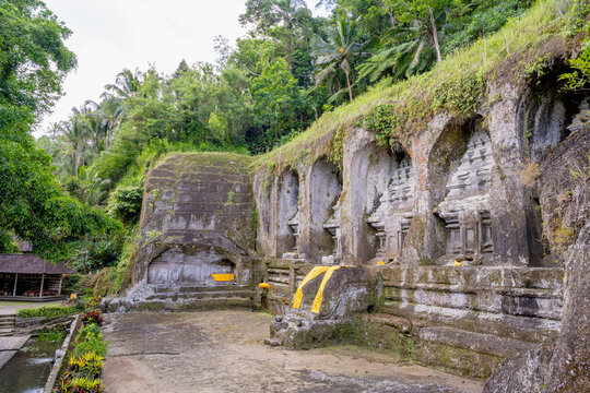 BALI, INDONESIA &ndash; OCTOBER 20, 2024: Ancient 11th-century rock-cut candi shrines carved into the cliff face at Gunung Kawi Temple.