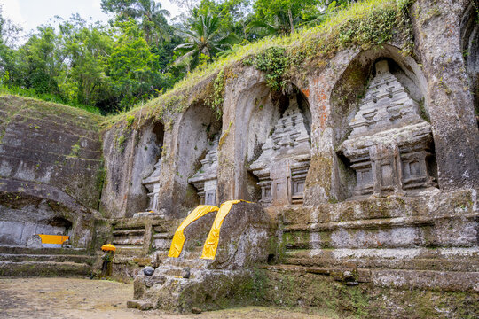 BALI, INDONESIA &ndash; OCTOBER 20, 2024: Ancient 11th-century rock-cut candi shrines carved into the cliff face at Gunung Kawi Temple.
