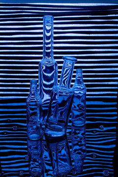 Empty glass bottles on a striped blue background