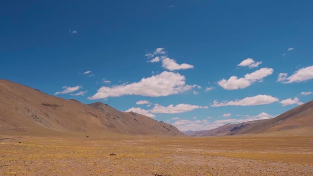 Wide angle shot of clouds above the dry Himalayan mountain range during the summer season as seen from More Plains on Leh Manali highway in Ladakh, India. Scenic natural background with copy space.