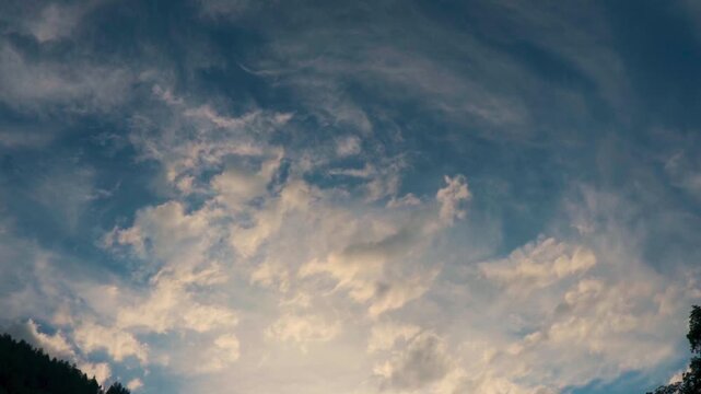 Wide angle shot of orange clouds in the sky after the rain during the sunset in monsoon season as seen from Manali in Himachal Pradesh, India. View of the clouds as seen from directly below it.