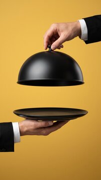 Hands of Waiter in Suit Revealing Empty Black Plate Under Cloche Dome Cover