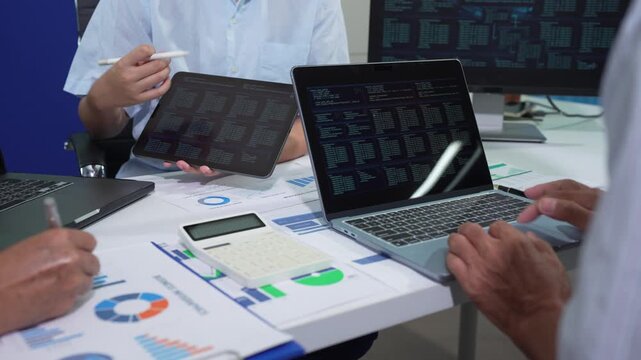 Businessmen team or financial data analysts working with tablets and laptop computers and data graphs together. Plan to analyzing projects in the office.