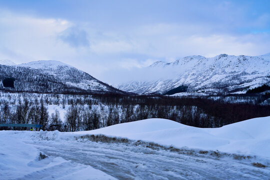 Scenic winter landscape of snow covered mountains and forest in Lofoten Norway