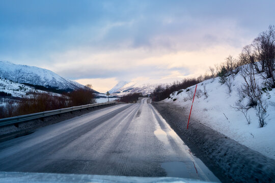 POV winter road trip driving on empty wet asphalt road in Lofoten Norway