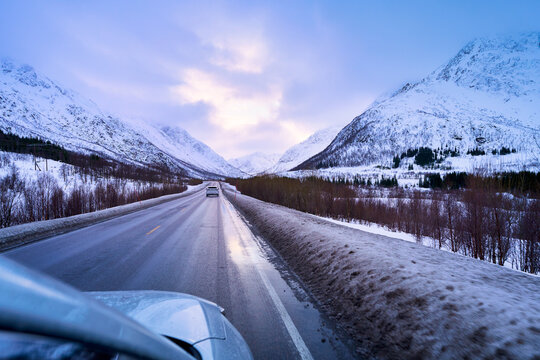 POV winter road trip driving through mountain valley in Lofoten Norway