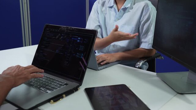 Male coder or developer working overtime using a computer display in problem solving at workplace.