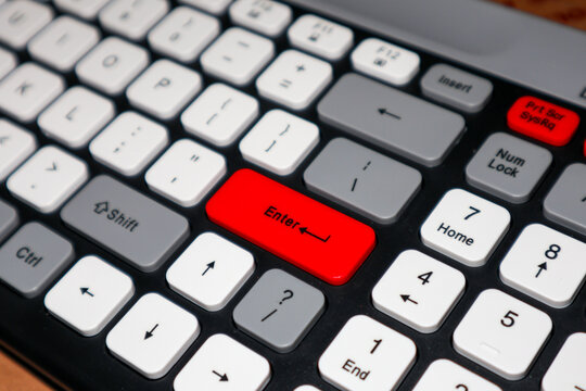 Close-up of a modern mechanical keyboard featuring a prominent red Enter key and gray and white keycaps