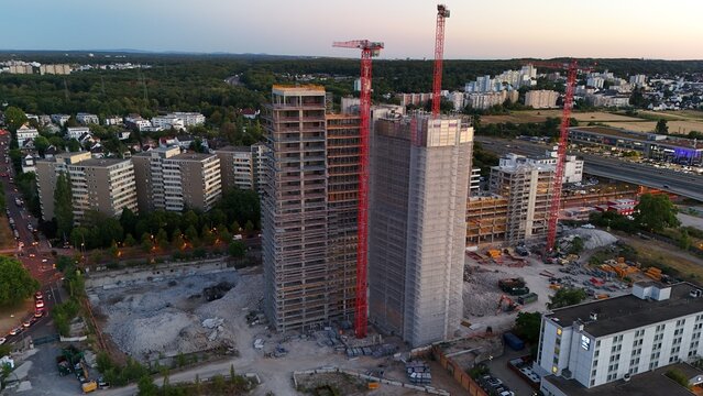 Aerial view of the Keppel Data Center construction site featuring tall concrete structures, red tower cranes, and surrounding urban infrastructure in Offenbach am Main, Hessen, Germany.