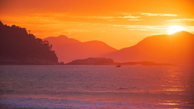 Golden sunset on tropical ocean coast in Rio de Janeiro Brazil with speed boat and copy space