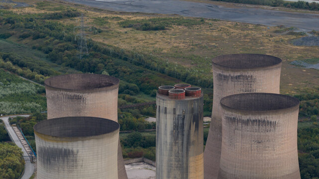Aerial view of the Fiddlers Ferry Power Station cooling towers surrounded by industrial landscape and greenery in Warrington, England, United Kingdom.
