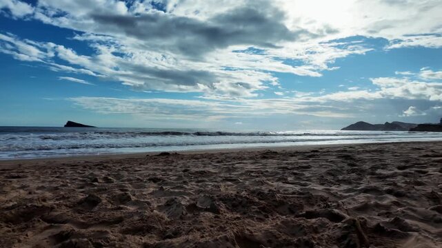 Low angle pan of Levante Beach and Benidorm Island, Spain