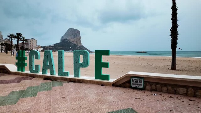 Calpe city sign with Penon de Ifach rock and beach, Spain