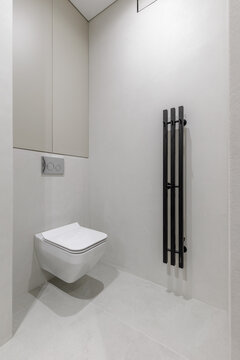 Modern Minimalist Restroom Interior with Wall-Hung Toilet and Black Towel Warmer