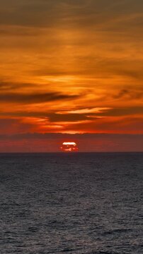 Vibrant sunset scenery over ocean waves during twilight. Static wide shot.