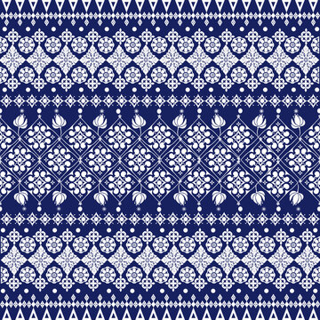 Elegant seamless border pattern featuring indigo blue floral ornaments combined with tribal geometric motifs inspired by traditional woven textiles. This decorative repeating design.